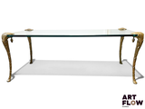 une table en verre avec des pieds dorés et un plateau en verre