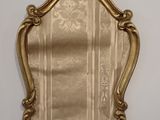 un miroir doré accroché au mur de la pièce