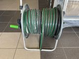 a hose on a cart with a green hose attached to it