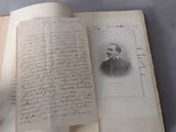 an open book with a handwritten letter and a picture of a man in a suit