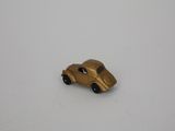small gold toy car on white surface with white background