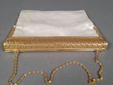 an old gold purse with a chain around it on a table
