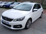 La voiture blanche est garée sur le bord de la route, dans le parking.