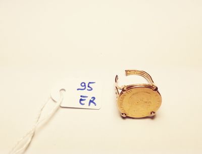 a gold ring with a coin on it next to a price tag