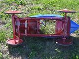 a red and blue toy car that is sitting in the grass