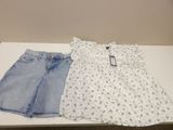 two pairs of shorts and a top on a table