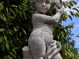 a statue of a child holding a bird on a pedestal