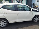 a picture of a small white car parked in a parking lot