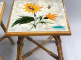 pair of bamboo side tables with hand painted flowers on them