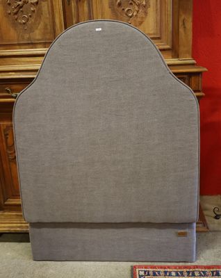 un lit avec une tête de lit et un tapis au sol