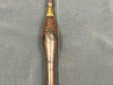 an image of a gold and silver toothbrush on a gray surface