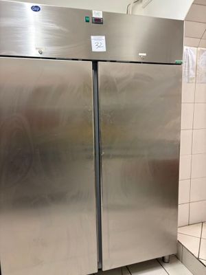 un réfrigérateur en acier inoxydable dans une salle de bains aux murs carrelés