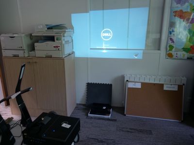 un bureau d'ordinateur avec un écran et une imprimante dans un coin