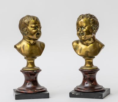a pair of brass busts of children on marble bases