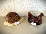 deux escargots en céramique posés l'un sur l'autre sur une table