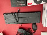 a keyboard, mouse, and other electronics on a red surface