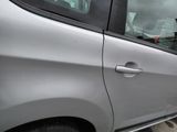 a silver car with a man in the driver ' s seat looking out the window