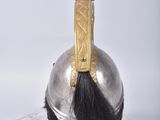 a silver helmet with a red feather on top