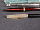 three pens sitting on a table next to each other