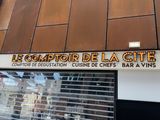une enseigne sur le mur d'un immeuble indiquant « Le Comptoir de la Cité »