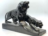statue d'un lion posée sur un socle en pierre, sur fond blanc