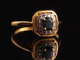 gros plan d'une bague en or avec des diamants noirs et blancs