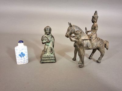 trois figurines représentant des personnes à cheval et un vase