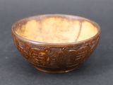 a brown bowl with designs on it on a black surface