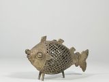 une figurine de poisson en bronze dont le corps et les pattes sont enfermés dans une cage