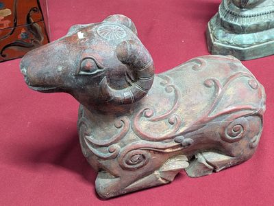 a statue of a cat sitting on a table next to other statues