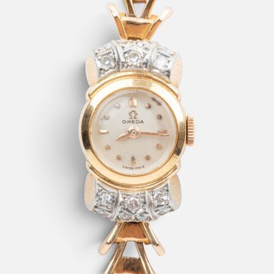 a close up of a gold and diamond watch on a white background