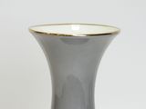 a gray vase with a gold rim sitting on a table