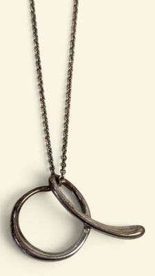 un gros plan d'un collier dont la chaîne présente un motif incurvé