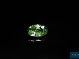 a green tourmaline gems on a black surface