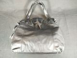 silver leather handbag with a star on the front of the bag