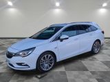 a white opel parked in a room with a checkered floor