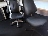 une chaise de bureau noire assise devant un bureau d'ordinateur