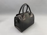 a black leather handbag with braid handles on a white background
