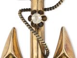une image représentant une ancre en or ornée d'une croix et de pierres turquoise