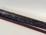 a wooden stick and a metal tube on a white surface