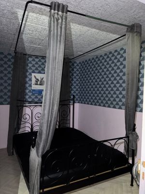 un lit à baldaquin dans une chambre au papier peint bleu et blanc