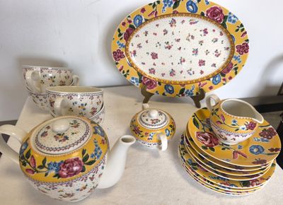 de nombreuses assiettes et tasses sur une table, avec une théière