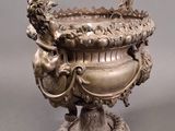 a silver vase with a dragon on it on a pedestal