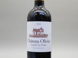 une bouteille de vin rouge posée sur une table blanche