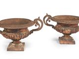 pair of antique bronze urns on pedestals on white background