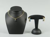 a black mannequin with a necklace and earrings on it