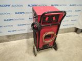 an image of a red machine sitting on top of a cement floor