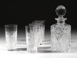 quatre verres et une carafe posés sur une table