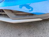 a close up of a blue car with a cat on it ' s front bumper