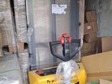 a yellow forklift truck that is next to a bunch of boxes